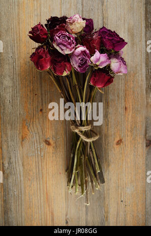Bouquet de roses séchées sur un sol en bois Banque D'Images