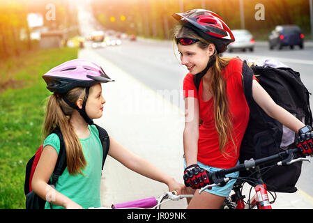 Cycliste Vélo fille. Les filles de porter un casque de vélo et de verre dans ciclyng avec sac à dos vélo. Pour les enfants à vélo sur Yellow Bike Lane. La nuance de couleur sur Banque D'Images