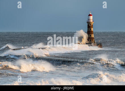 Éclaboussures des vagues contre Roker phare à l'extrémité d'une jetée, Sunderland, Tyne et Wear, Angleterre Banque D'Images