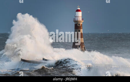 Éclaboussures des vagues contre Roker phare à l'extrémité d'une jetée, Sunderland, Tyne et Wear, Angleterre Banque D'Images