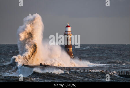 Éclaboussures des vagues contre Roker phare à l'extrémité d'une jetée, Sunderland, Tyne et Wear, Angleterre Banque D'Images