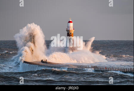 Éclaboussures des vagues contre Roker phare à l'extrémité d'une jetée, Sunderland, Tyne et Wear, Angleterre Banque D'Images