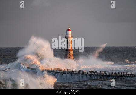 Éclaboussures des vagues contre Roker phare à l'extrémité d'une jetée, Sunderland, Tyne et Wear, Angleterre Banque D'Images