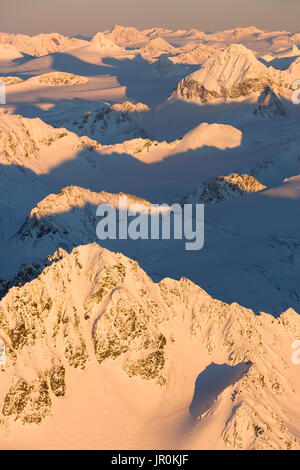 Peaks d'une chaîne de montagnes couvertes de neige Rose rougeoyant au coucher du soleil, Kachemak Bay State Park, Alaska, États-Unis d'Amérique Banque D'Images