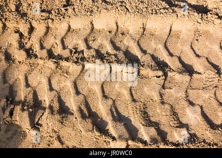 Gros plan de l'impression des pneus sur le sable en construction site Banque D'Images
