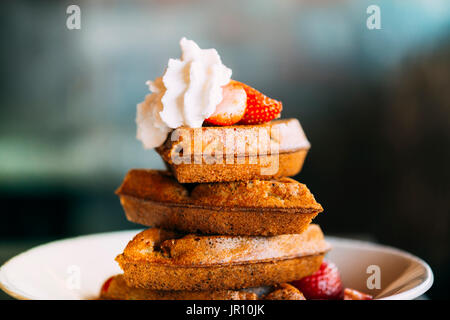 Gaufres avec crème fouettée sucrée topping et fraises Banque D'Images