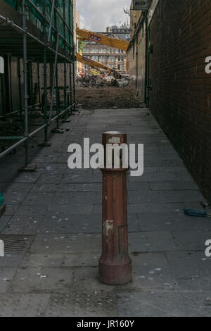 La chaussée en vieux métal post ruelle conduisant à des travaux de démolition, Glasgow, Écosse, Royaume-Uni Banque D'Images