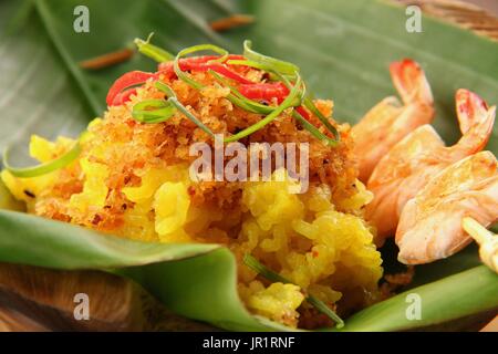 Ketan Serundeng Udang. Le curcuma Riz collant à la noix de coco grillée et de crevettes Satay Banque D'Images