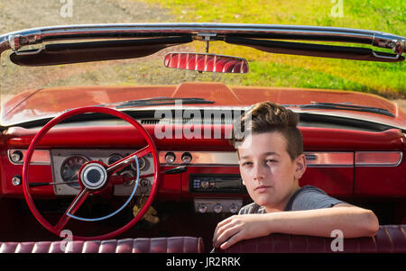 Portrait Of A young woman with Brown ondulés assis avec ses bras sur le siège d'un Convertible 1969 Chevrolet Bel Air 1960 Banque D'Images