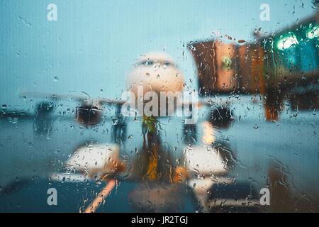 Un aéroport très fréquenté dans la pluie. Pousser l'arrière de l'avion avant le vol. Banque D'Images