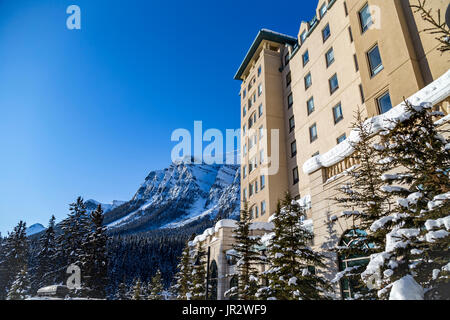 Un angle de côté vue sur les montagnes couvertes de neige en hiver et le Fairmont Château Lake Louise Hôtel de villégiature dans les Rocheuses Banque D'Images