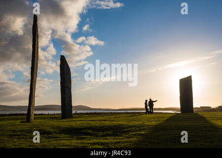 Les touristes à Les Menhirs de Stenness, Orkney en lumière du soir coucher du soleil Banque D'Images