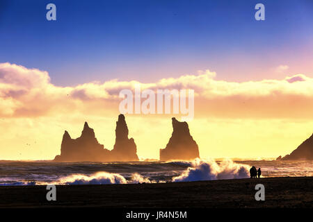 De soleil colorés sur les formations de roche de basalte 'Troll' orteils sur plage noire. Vik, Reynisdrangar, Islande Banque D'Images