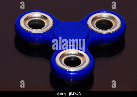 Spinner sur fond noir libre. Fidget bleu close-up en perspective. Banque D'Images