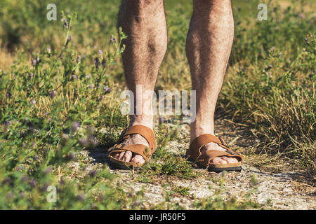 Dans les jambes des hommes sandales en cuir brun debout sur un sentier Banque D'Images