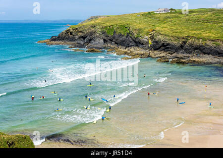 Surf à la plage de Poldhu Cove avec des gens apprenant à surfer, Cornwall, Royaume-Uni Banque D'Images