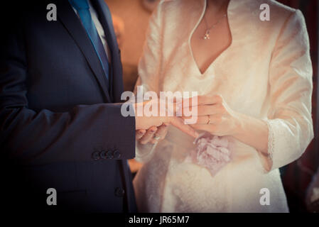 L'homme de mettre l'anneau de mariage à son doigt de la mariée, Close up, onirique. Banque D'Images