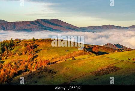 Au fil des champs rurales nuages dans les montagnes. vue spectaculaire de la campagne avec crête de montagne dans une distance au lever du soleil Banque D'Images