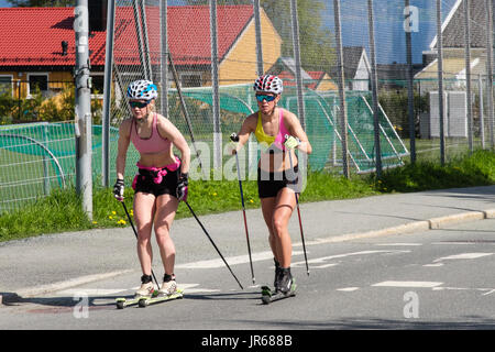Deux femmes sur skis à roulettes rollerskiing nordique sur une route en été. Norvégien typique de vie actif. Trondheim, Sør-Trøndelag, Norvège, Scandinavie Banque D'Images