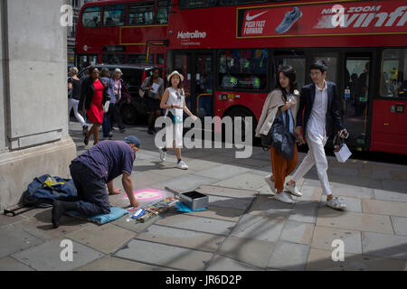 Artiste de rue, Nick C fait un portrait au pastel d'une fille sur rose, pour les clients et les piétons, le 31 juillet 2017, dans la région de Oxford Street, Londres, Angleterre. Banque D'Images