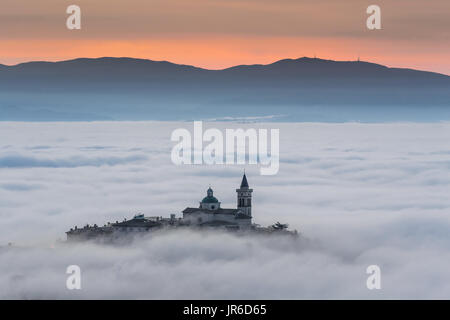 Voir Trevi Ombrie (Italie) au coucher du soleil avec brouillard dans la vallée. Banque D'Images