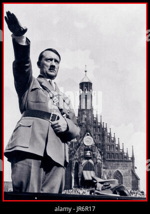 Führer Adolf Hitler en uniforme militaire nazie donne Heil Hitler salute de sa voiture alors qu'à un rassemblement du parti nazi dans les années 1930, Adolf Hitler salue foule depuis sa voiture ouverte au défilé Reichsparteitag Nürnberg Allemagne Banque D'Images