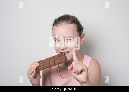 Fille de mordre une barre de chocolat Banque D'Images