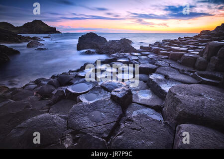 Coucher de soleil sur la formation des roches basaltiques Giant's Causeway, Port Ganny Bay et Great Stookan, comté d'Antrim, en Irlande du Nord, Royaume-Uni