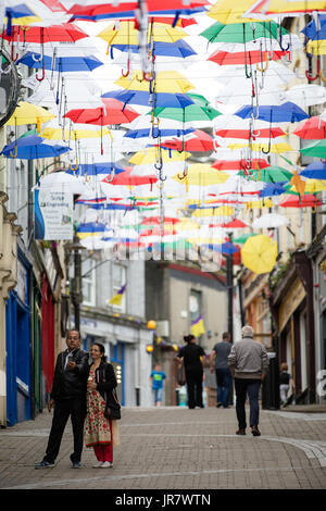 Couple sur une rue selfies slaney dans pilonya Irlande décorée de parapluies flottantes pour le rockin' food festival Banque D'Images