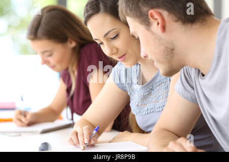 Aider l'élève à un camarade de classe avec l'autre fille dans l'arrière-plan Banque D'Images