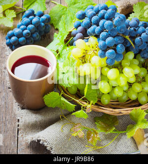 Le vin rouge et les raisins. Vin et raisin dans réglage vintage avec des bouchons sur table en bois Banque D'Images