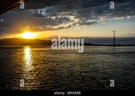 Coucher de soleil avec des rayons d'or au large de la côte de la Sicile dans la mer Méditerranée. Banque D'Images