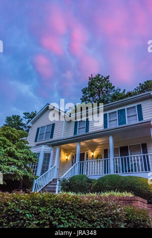 Coucher Soleil nuages colorés peindre le ciel comme soir tombe sur une maison dans la région métropolitaine d'Atlanta, Géorgie. (USA) Banque D'Images