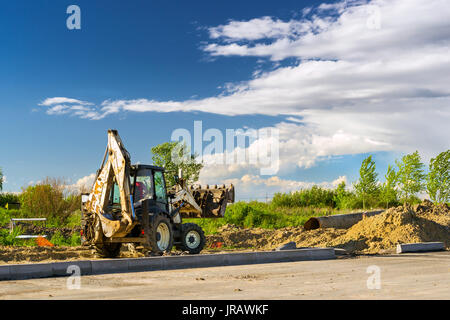 Tracteur avec godet effectue des travaux d'excavation. La construction de la route de contournement à grande vitesse autour de Krasnoe Selo, Saint Petersburg. Équipement machine lourde fo Banque D'Images