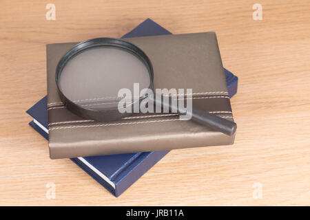 Portrait de loupe située sur deux planificateurs contre fond de bois Banque D'Images