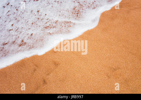 Full Frame shot d'une mousse lisse vague couvrant le sable Banque D'Images