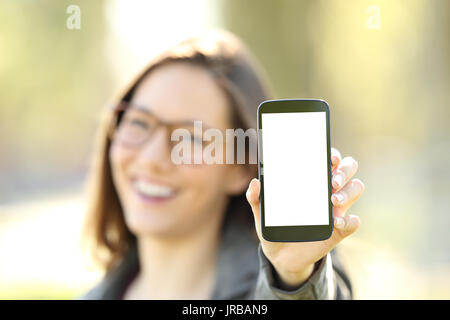 Femme heureuse de vous montrer un écran de téléphone intelligent à l'extérieur dans la rue Banque D'Images