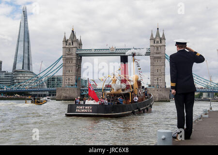 Le Portwey ST, un 90-year-old remorqueur à vapeur, qui a été construit sur la Clyde en 1927, et qui sous le commandement de la Royal Navy pendant la Seconde Guerre mondiale, est salué par le commandant Richard Pethybridge comme elle fume, Président de HMS passé la Royal Navy établissement côtier permanent sur la Tamise à Londres, à l'occasion du 90e anniversaire des remorqueurs. Banque D'Images