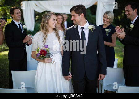 Heureux couple marche main dans la main au cours de mariage Banque D'Images