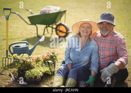Portrait of smiling senior couple sitting in garden Banque D'Images