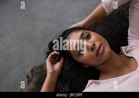 Young woman relaxing on bed plus de marbre à la maison Banque D'Images