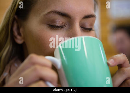 Close up of young businessman drinking coffee at cafe Banque D'Images