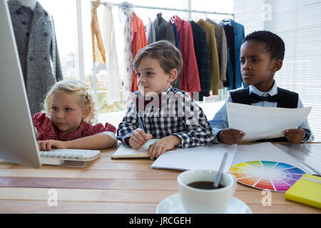 Businesswoman expliquant aux collègues masculins sur ordinateur dans creative office Banque D'Images