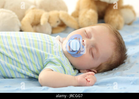 Mignon bébé dormir avec une sucette sur un lit Banque D'Images