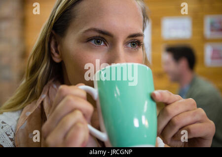 Près de young woman having coffee in cafe Banque D'Images