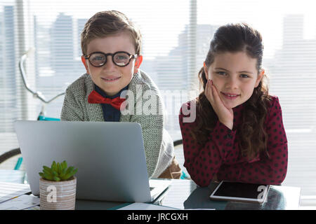 Portrait of smiling business people standing at table in office Banque D'Images