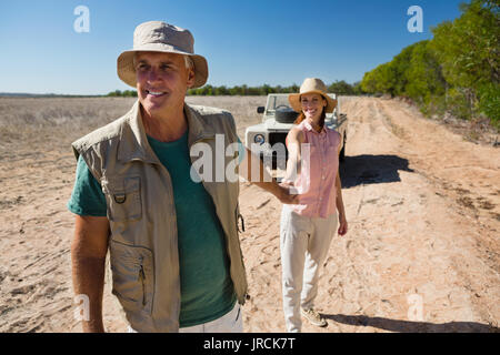 Couple holding hands en marchant sur le paysage au cours de journée ensoleillée Banque D'Images
