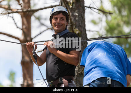 MEZIO, PORTUGAL - 22 juillet 2017 : l'homme aventureux se prépare à une diapositive dans la tyrolienne à travers la forêt. 22 juillet 2017, Mezio, Portugal. Banque D'Images