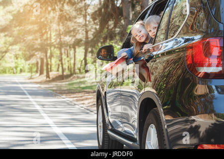 Voyager en voiture rouler ensemble famille frère et soeur se pencher hors de la fenêtre Banque D'Images