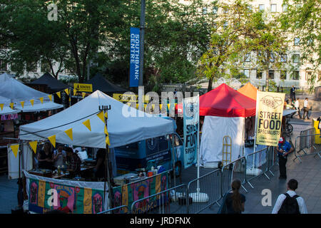 Street Food Market à Londres Royaume-Uni vendre des tentes affamées rouge blanc soda barrières métal arbres parc panneaux sur le remblai vendre vendre savoureux affamés Banque D'Images